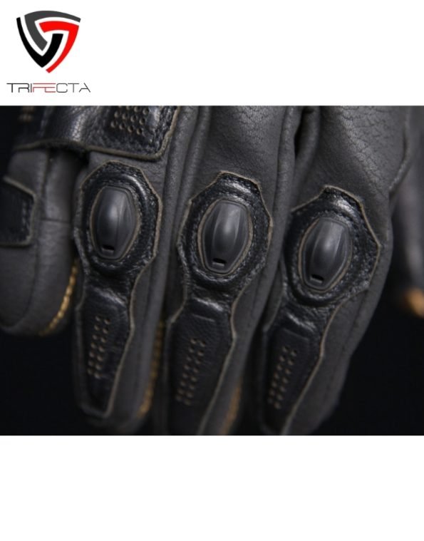 Close-up of a black motorcycle glove featuring reinforced padding on the fingers and knuckles, with textured grip enhancements on the palm area.