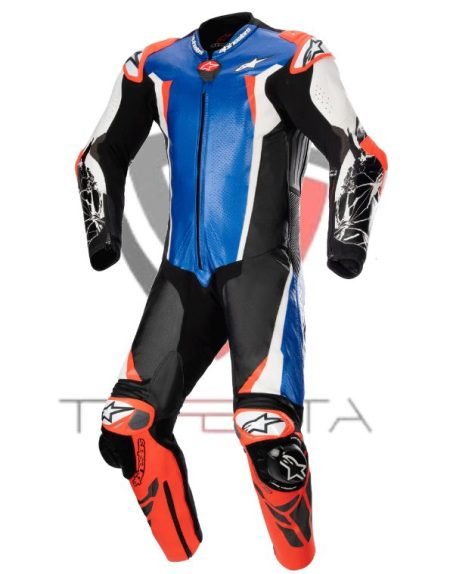 A professional motorcycle racing suit by Alpinestars, featuring a predominantly blue, black, and white color scheme with red accents. The suit has a large Alpinestars logo on the chest, lower legs, and arms. It includes integrated protective elements such as reinforced knee pads and shoulder guards. The suit appears to be designed for high performance and safety with pre-curved sleeves for riding comfort and is displayed against a white background.