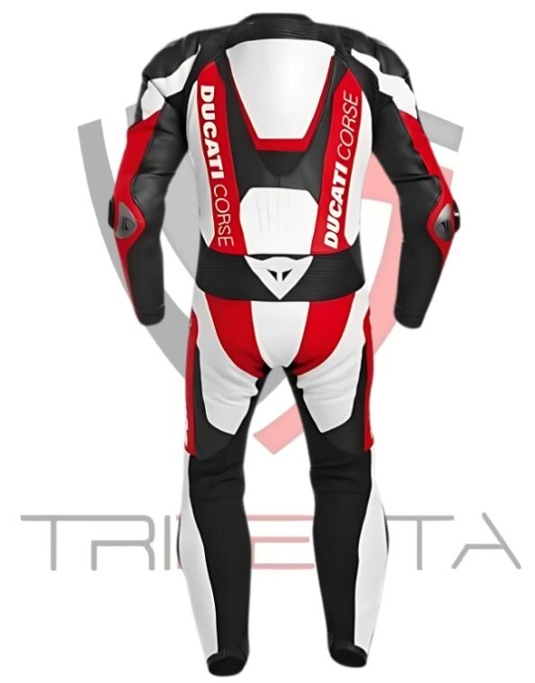 A Ducati Corse branded motorcycle racing suit displayed against a white background. The suit is predominantly black and red with white accents, featuring the Ducati Corse logo on the chest, arms, and legs. The design includes protective padding at the shoulders, elbows, and knees. The word ‘TRISETTA’ is visible at the bottom of the image in a stylized font