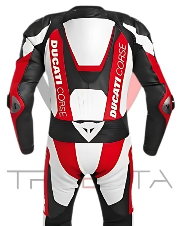 A Ducati Corse branded motorcycle racing suit displayed against a white background. The suit is predominantly black and red with white accents, featuring the Ducati Corse logo on the chest, arms, and legs. The design includes protective padding at the shoulders, elbows, and knees. The word ‘TRISETTA’ is visible at the bottom of the image in a stylized font